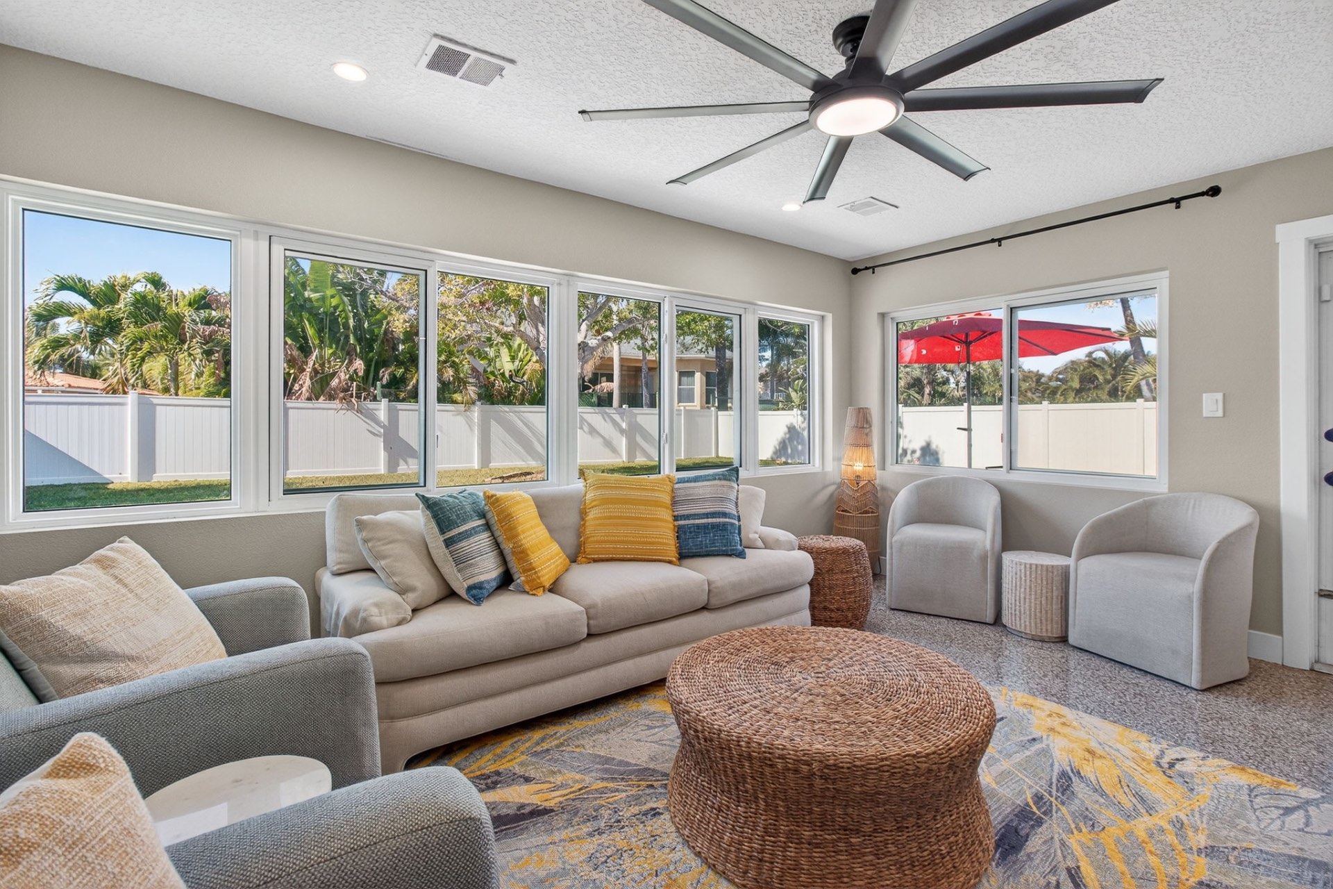 Sunroom lined with windows overlooking palms and the backyard