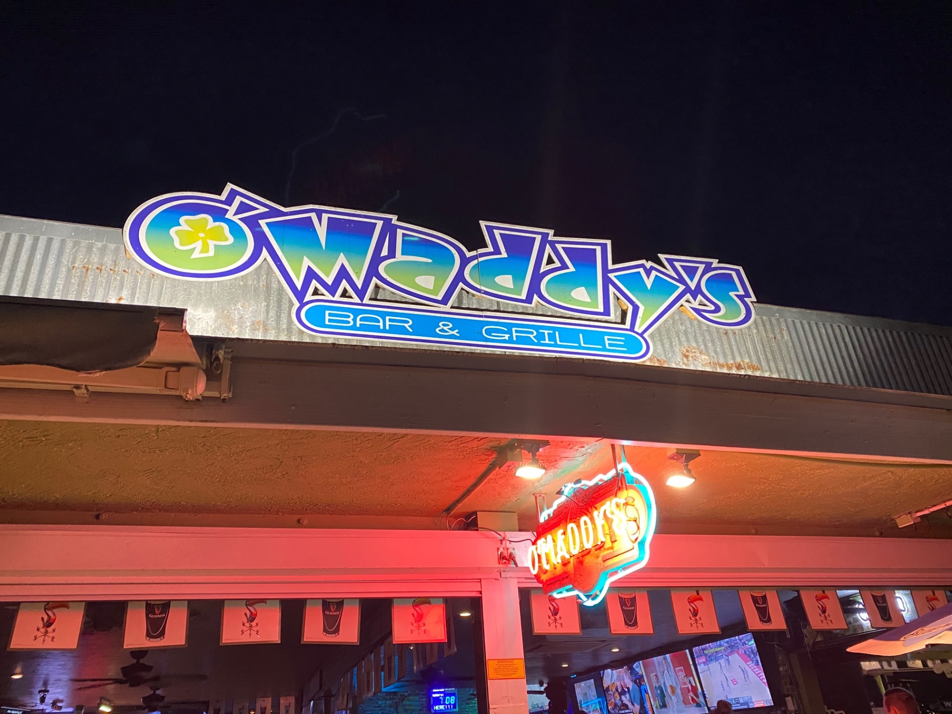 Neon sign of O'Maddy's Bar and Grille in Gulfport lit up at night